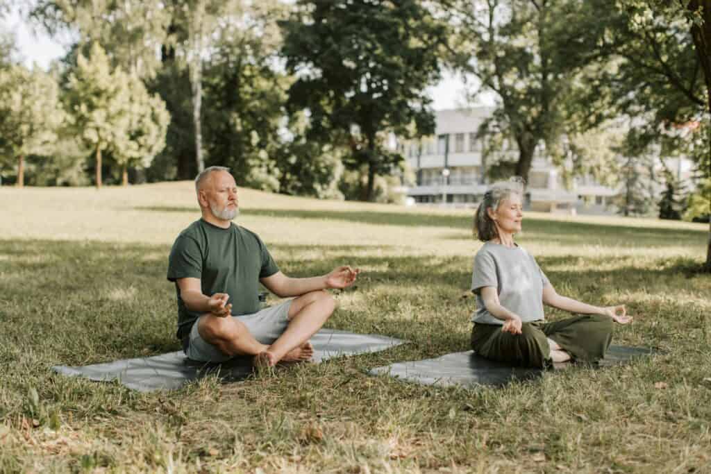 A couple is meditating at the park
