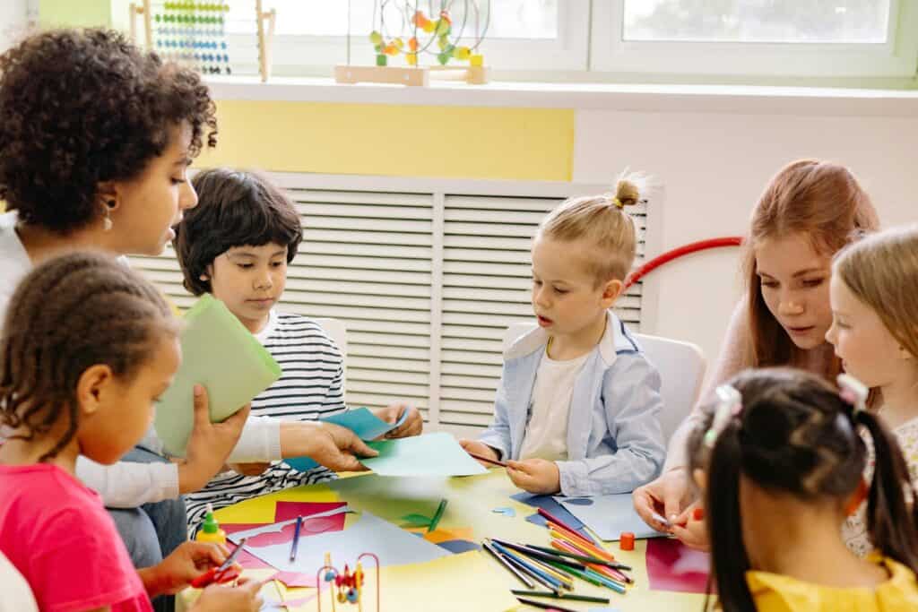 Teacher and young students doing artwork in the concept of 'Top schools in West London'.