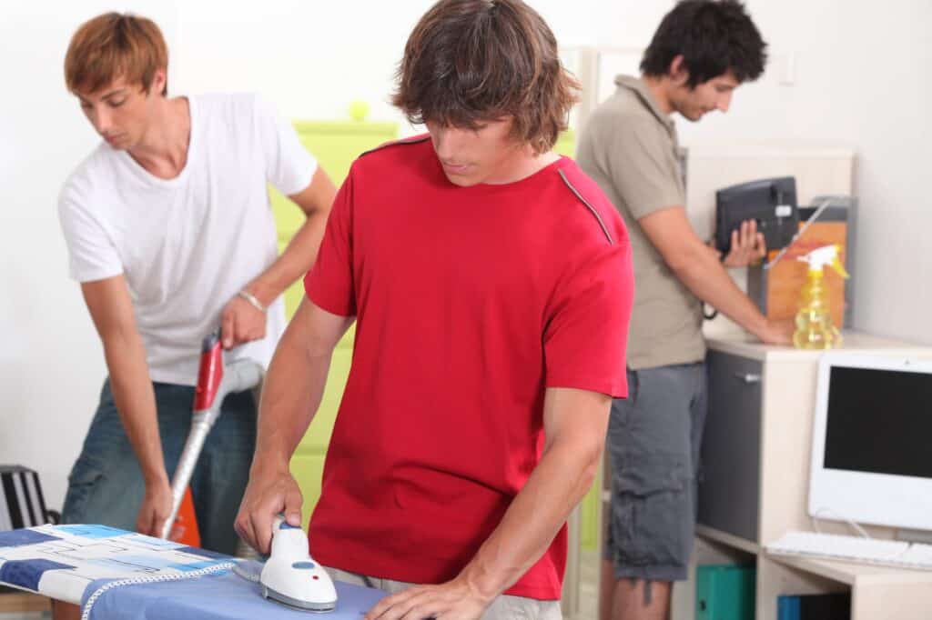 Three male flatmates cleaning together