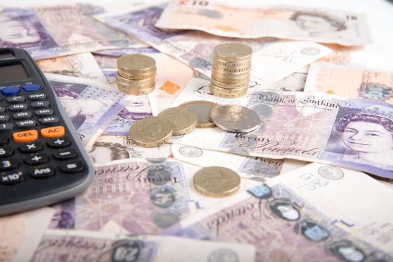 British pound bills and coins with a calculator in the concept of 'West London removals cost'.