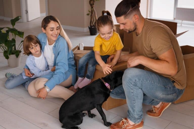 A young family with a pet just arrived into their new home in the concept of 'How to Settle into a New Home After Moving to West London'.